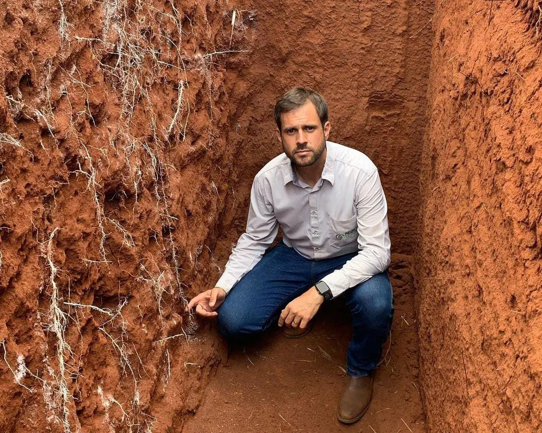 João Ancheschi dentro de uma trincheira de solo, mostrando as raízes no perfil